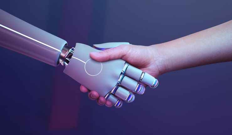 Using a robotic hand, the person shakes hands.